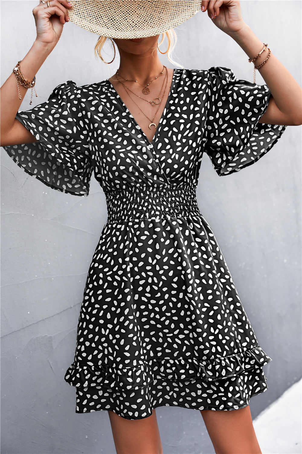 Black surplice dress with white abstract print, puff short sleeves, smocked waist, tiered hem