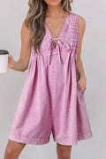 Pink mineral-wash denim romper with pleated bib, V-neck, sleeveless silhouette