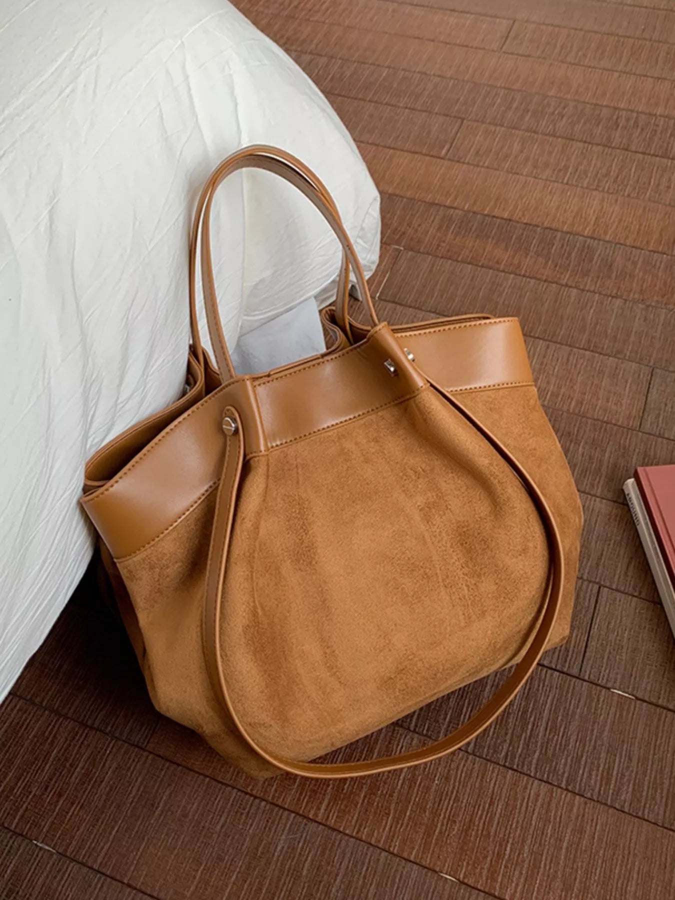 Brown suede tote-style shoulder bag with leather handles and side panels