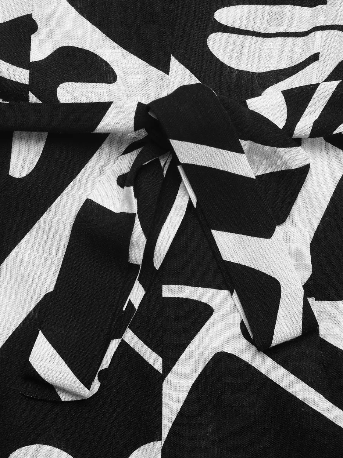 Black-and-white abstract printed fabric with gathered knot detail, woven texture.