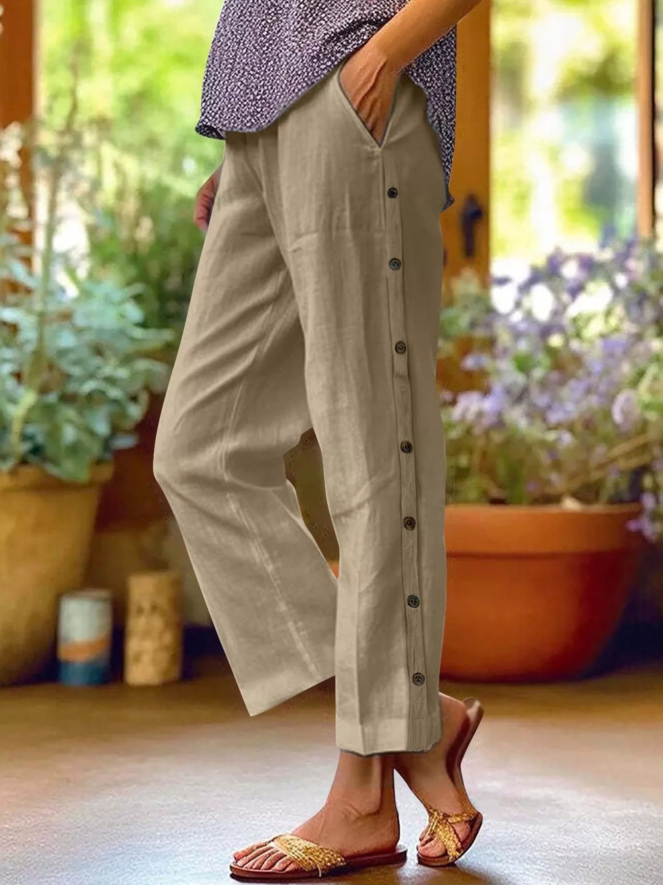 Khaki green polyester pants with side buttons, side pockets, and elastic waistband