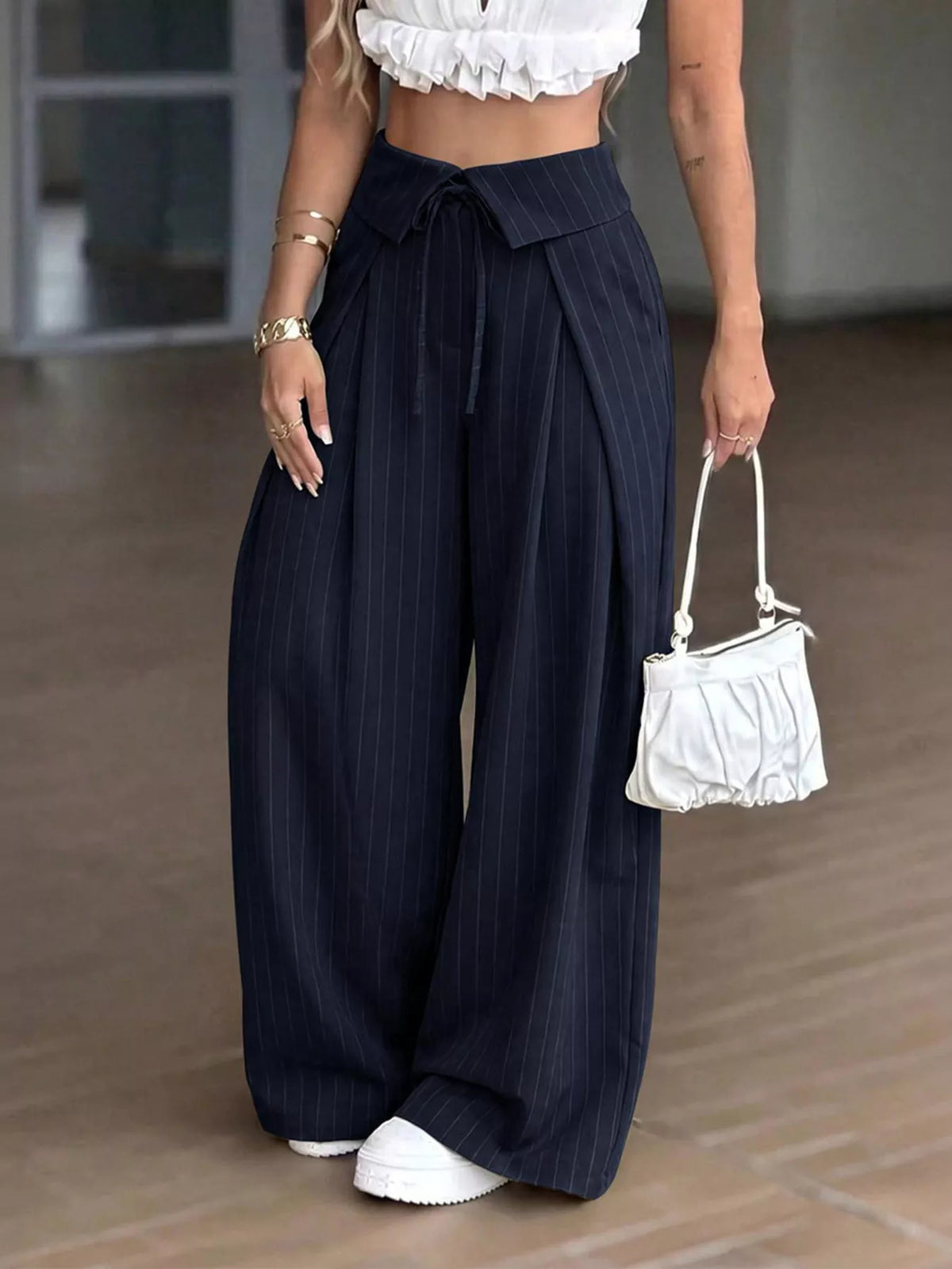 High-waisted wide-leg pinstripe pocket pants in navy blue with tied waist and pleats.