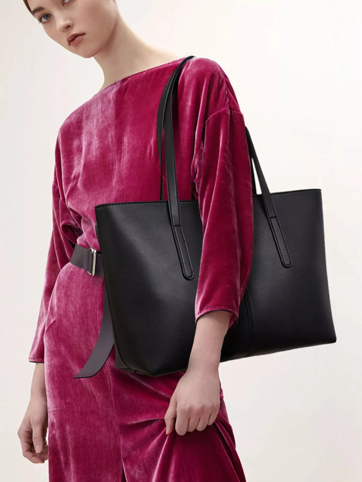 Black medium vegan leather tote bag with two top handles and zippered opening