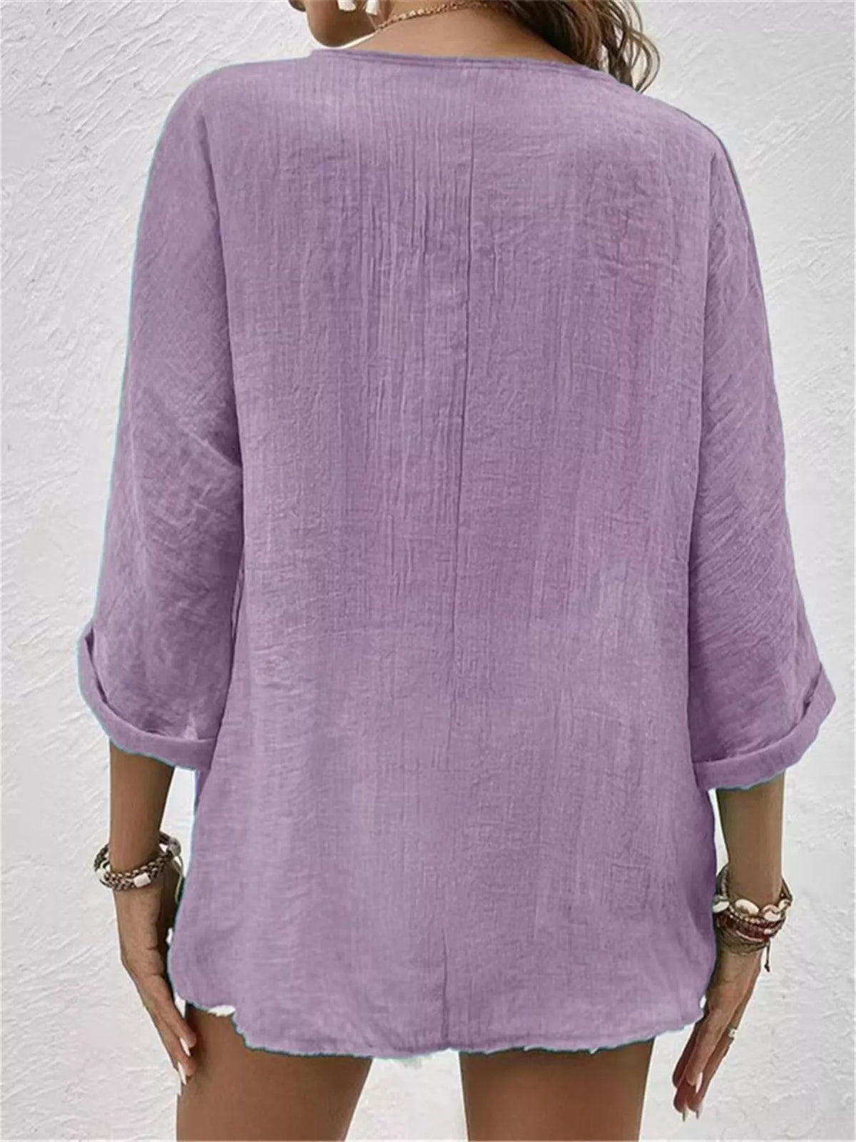 Back view of purple V-neck button blouse with 3/4 sleeves and relaxed fit