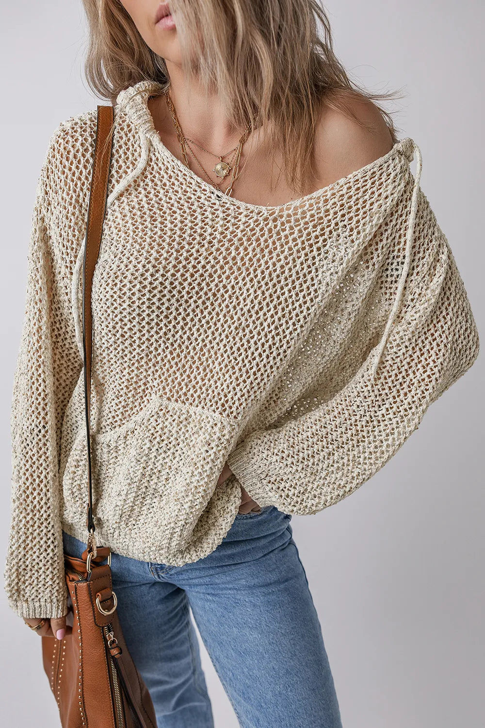 Beige openwork knit hooded top with slouchy fit, draped hood, and front pouch pocket