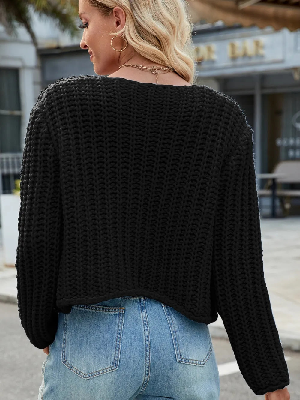 Black knit cardigan back view with round neckline and textured knit fabric