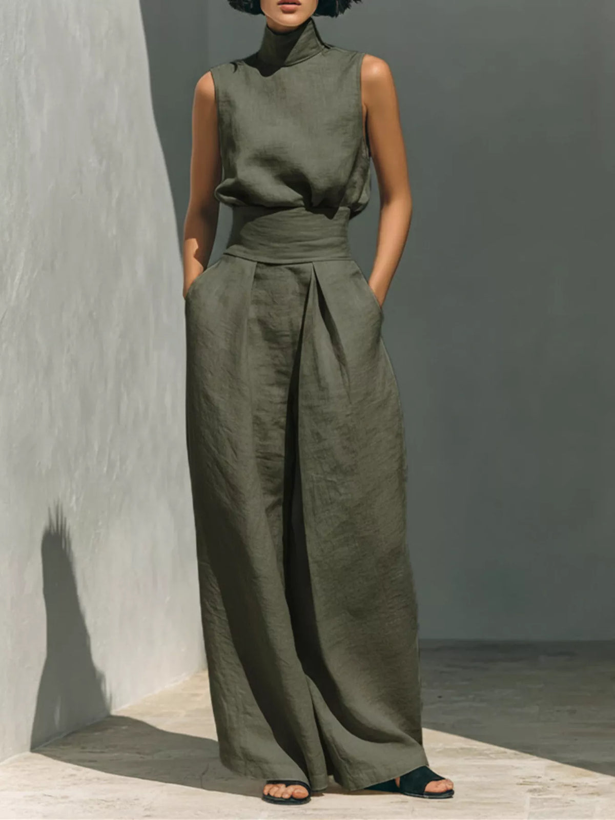Sleeveless wide-leg jumpsuit in olive green with smocked waist and high neckline