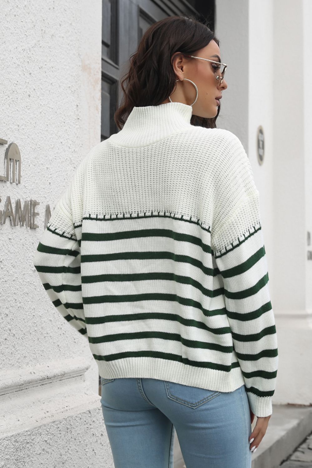 White knit turtleneck drop-shoulder sweater, back view, dark green and black striped yoke