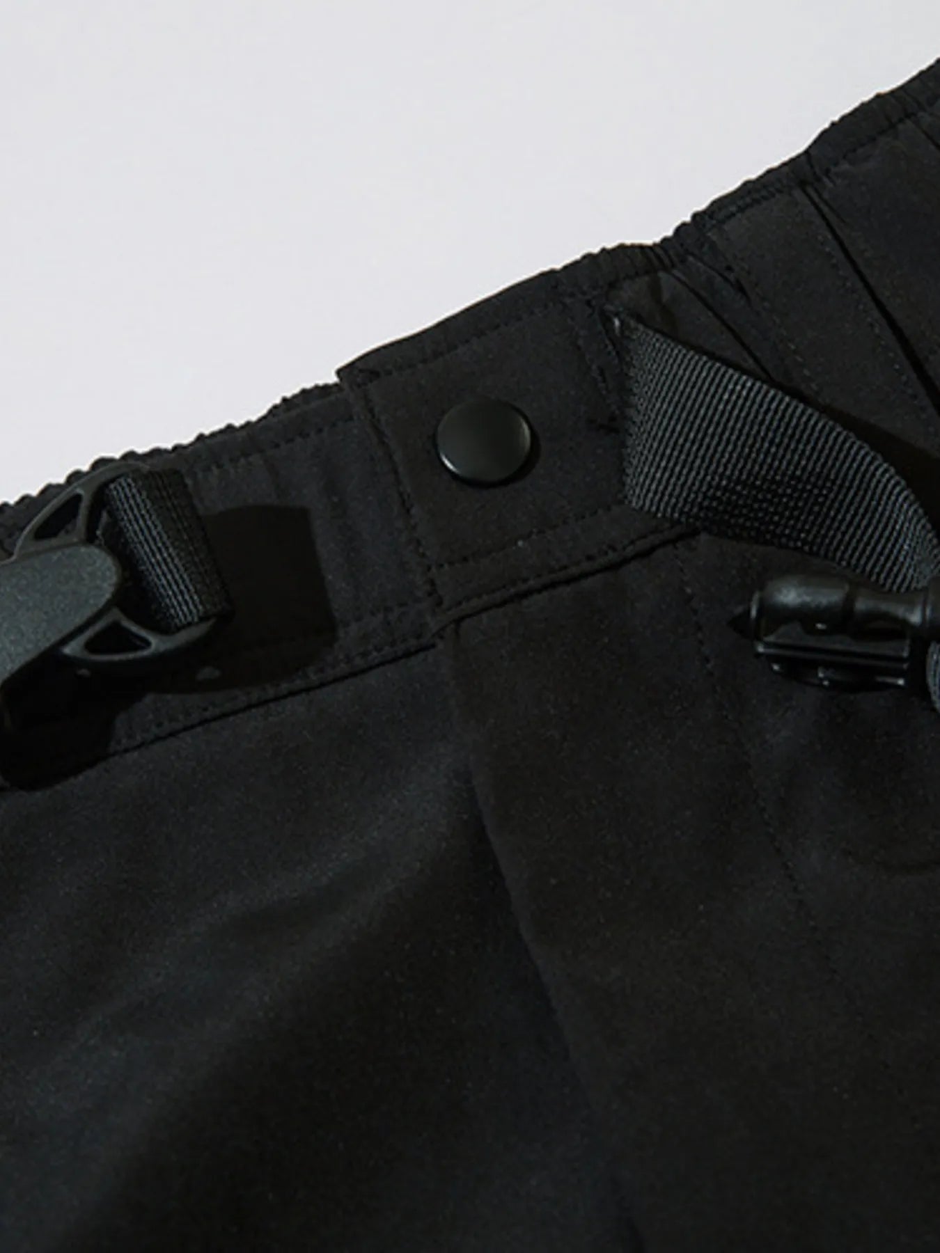 Black cargo joggers with elastic waistband and side cargo pocket button closure