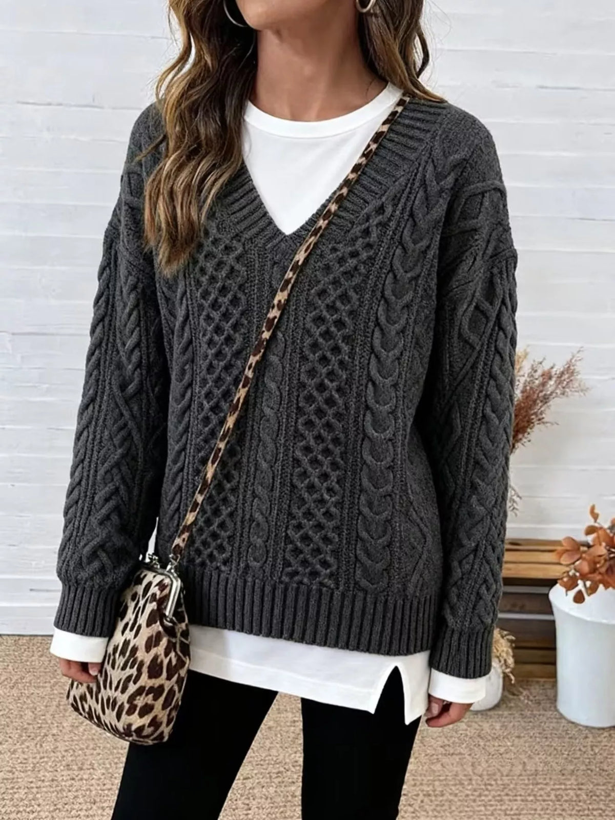 Gray cable knit sweater with dropped shoulders, V-neck, and ribbed trim