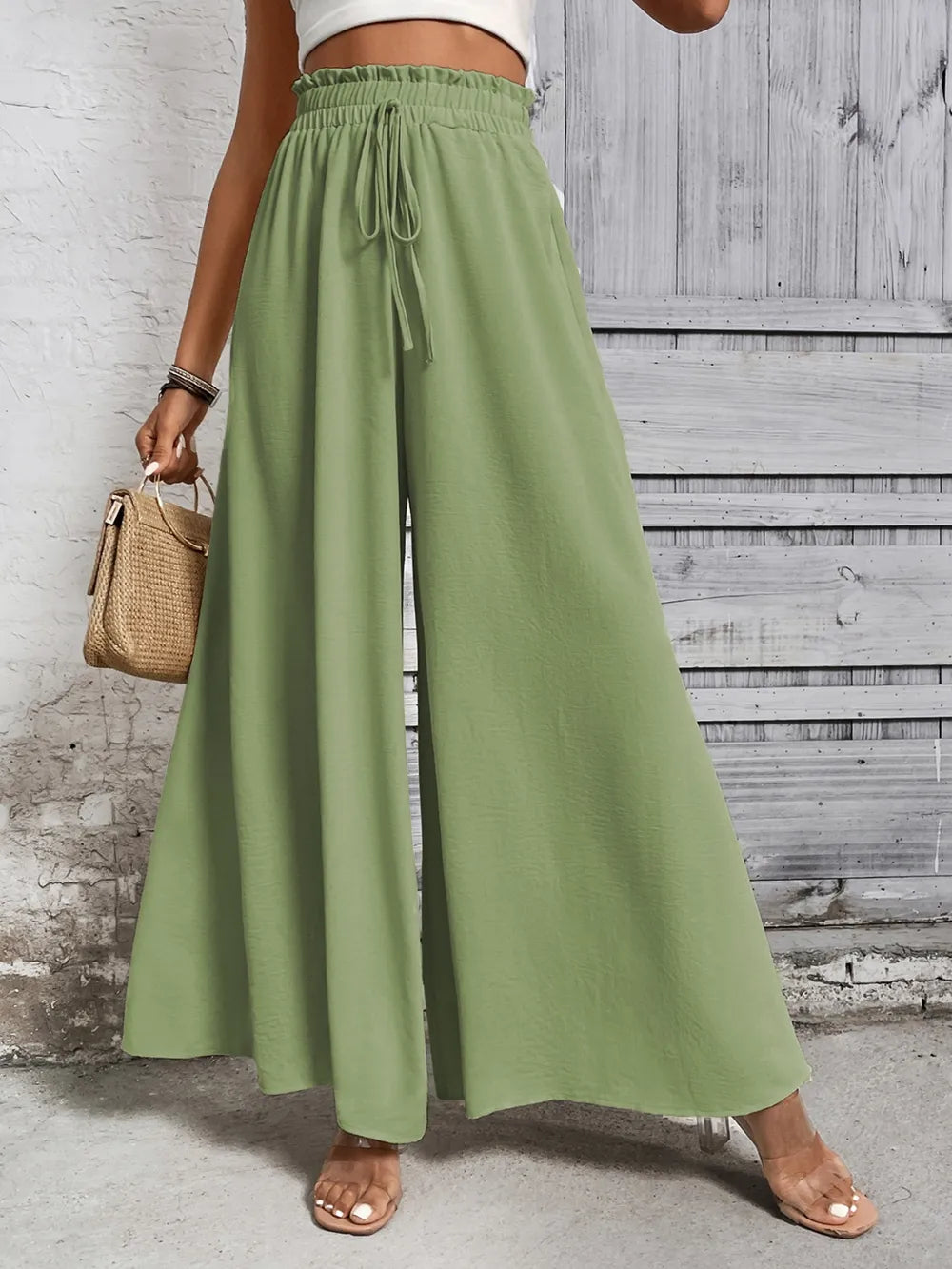 High-waist wide-leg pants in light green with drawstring tie at the waistband