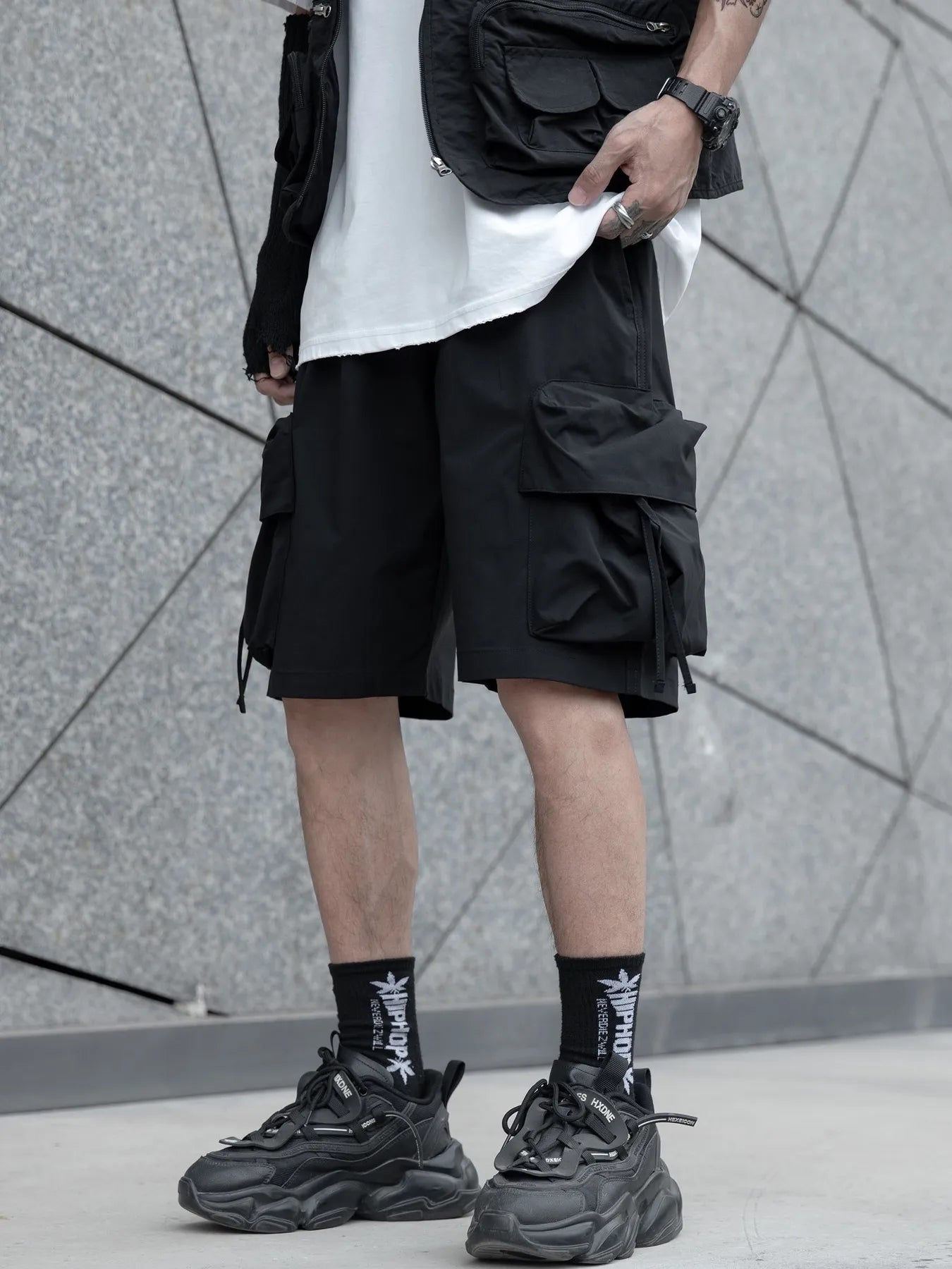 Black cargo shorts with large side pocket panels and utility straps