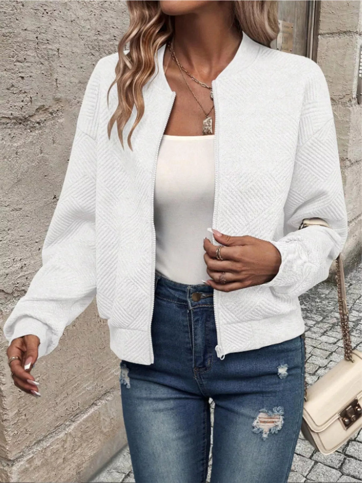 White textured knit zip-up jacket with front pockets and zippered closure
