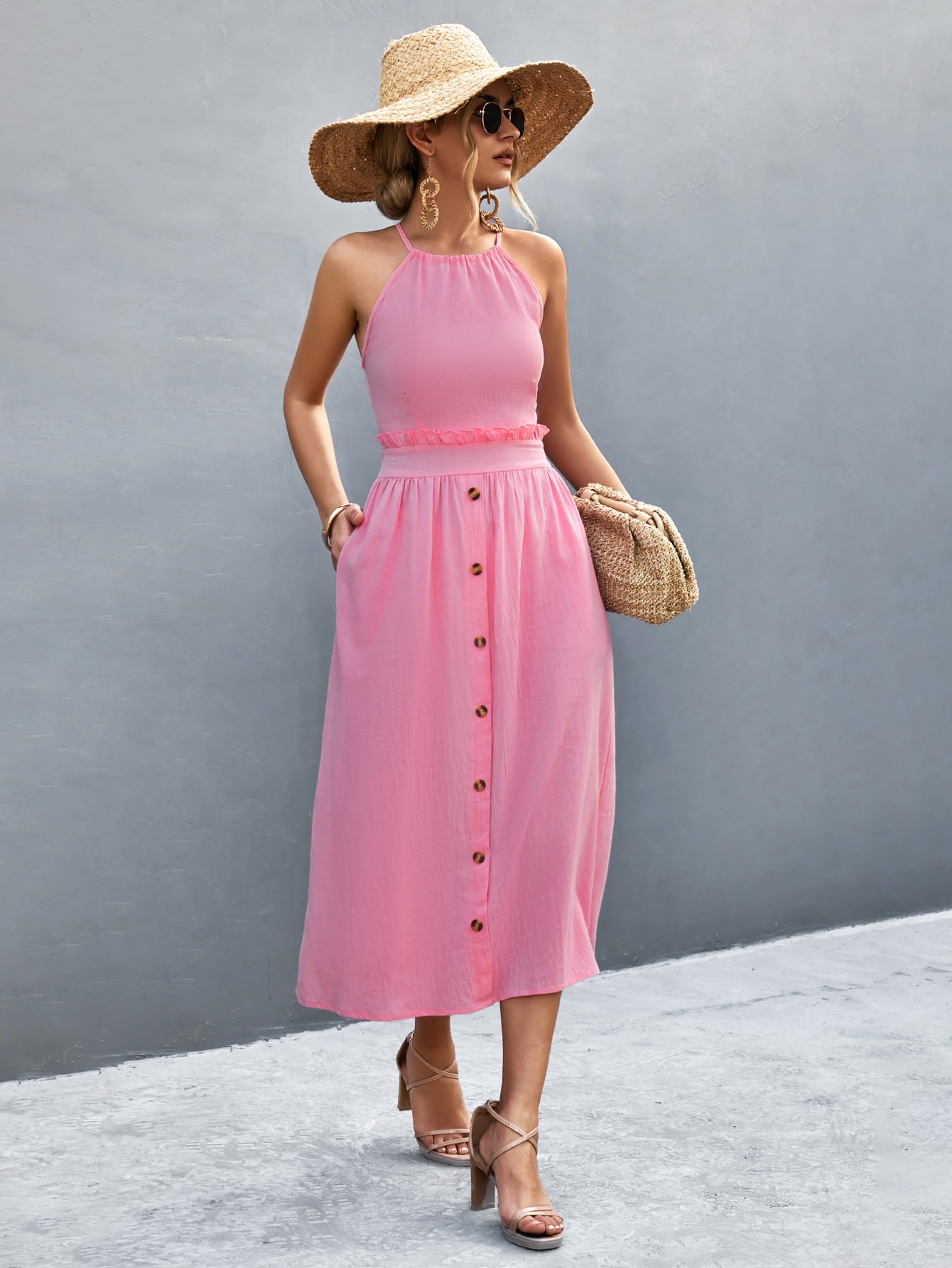 Pink button-front halter neck midi dress with frill trim and sleeveless cut.