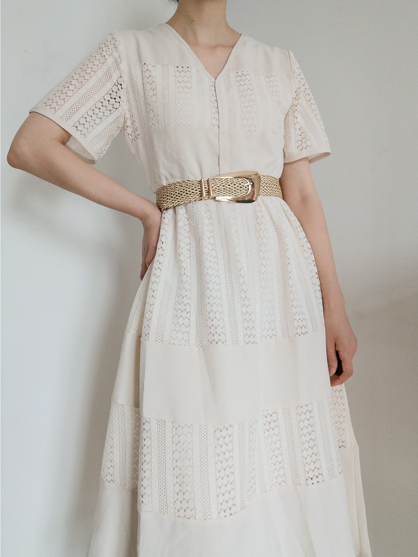 Woven braid belt with gold-tone irregular buckle worn at the dress waist