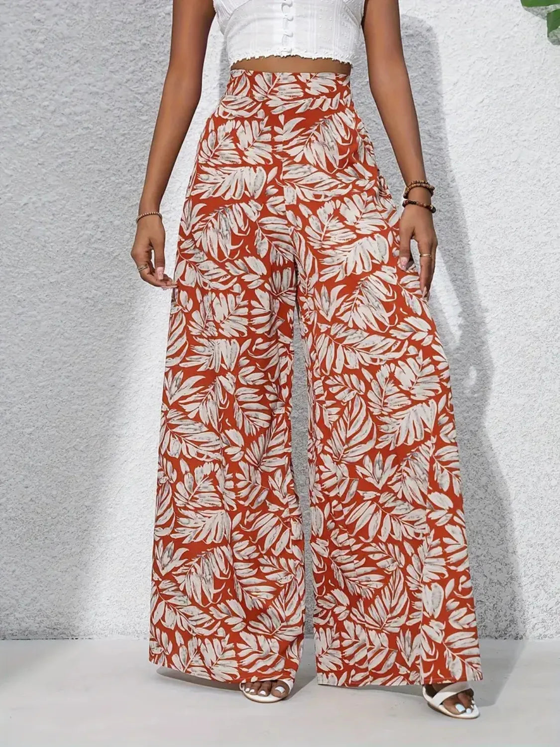High-waist wide-leg pants in rust and white with allover leaf pattern