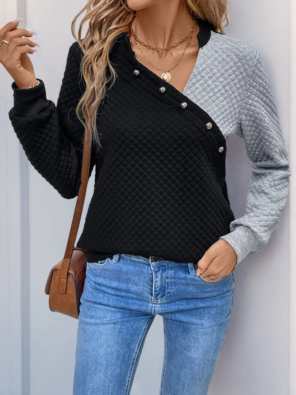 Contrast long-sleeve sweatshirt with decorative buttons, black quilted body and gray sleeves
