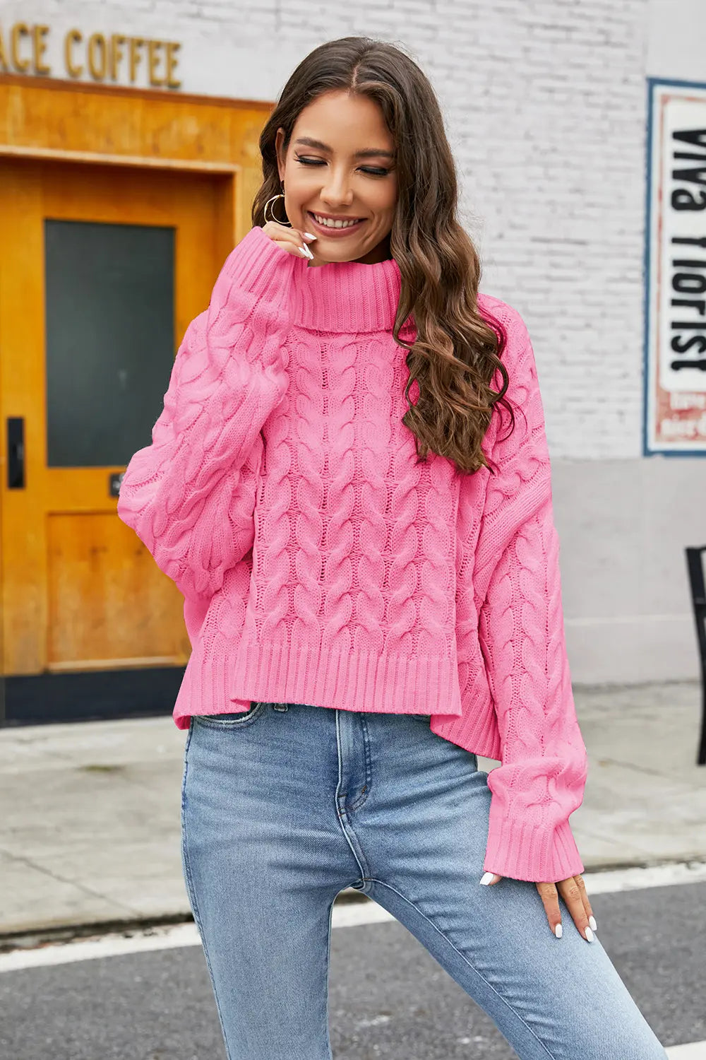 Hot pink cable-knit turtleneck sweater with long sleeves and textured cable pattern