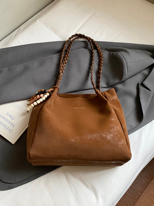 Caramel brown braided strap shoulder bag with top handles and beaded front charm