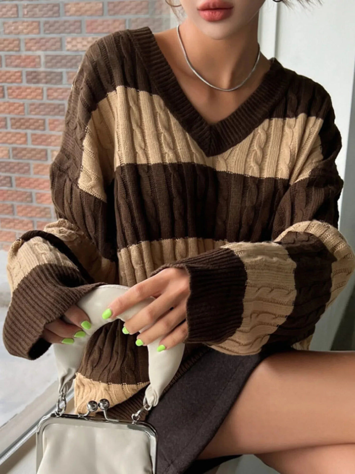 Dark brown and beige striped cable knit V-neck sweater with long ribbed sleeves