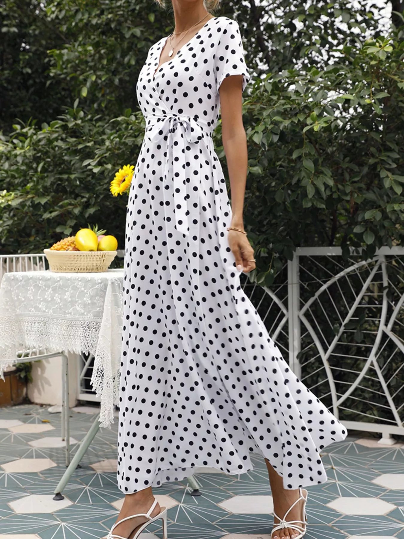 Polka-dot wrap maxi dress with belt, white with black dots, V-neck, side view, flowing maxi skirt