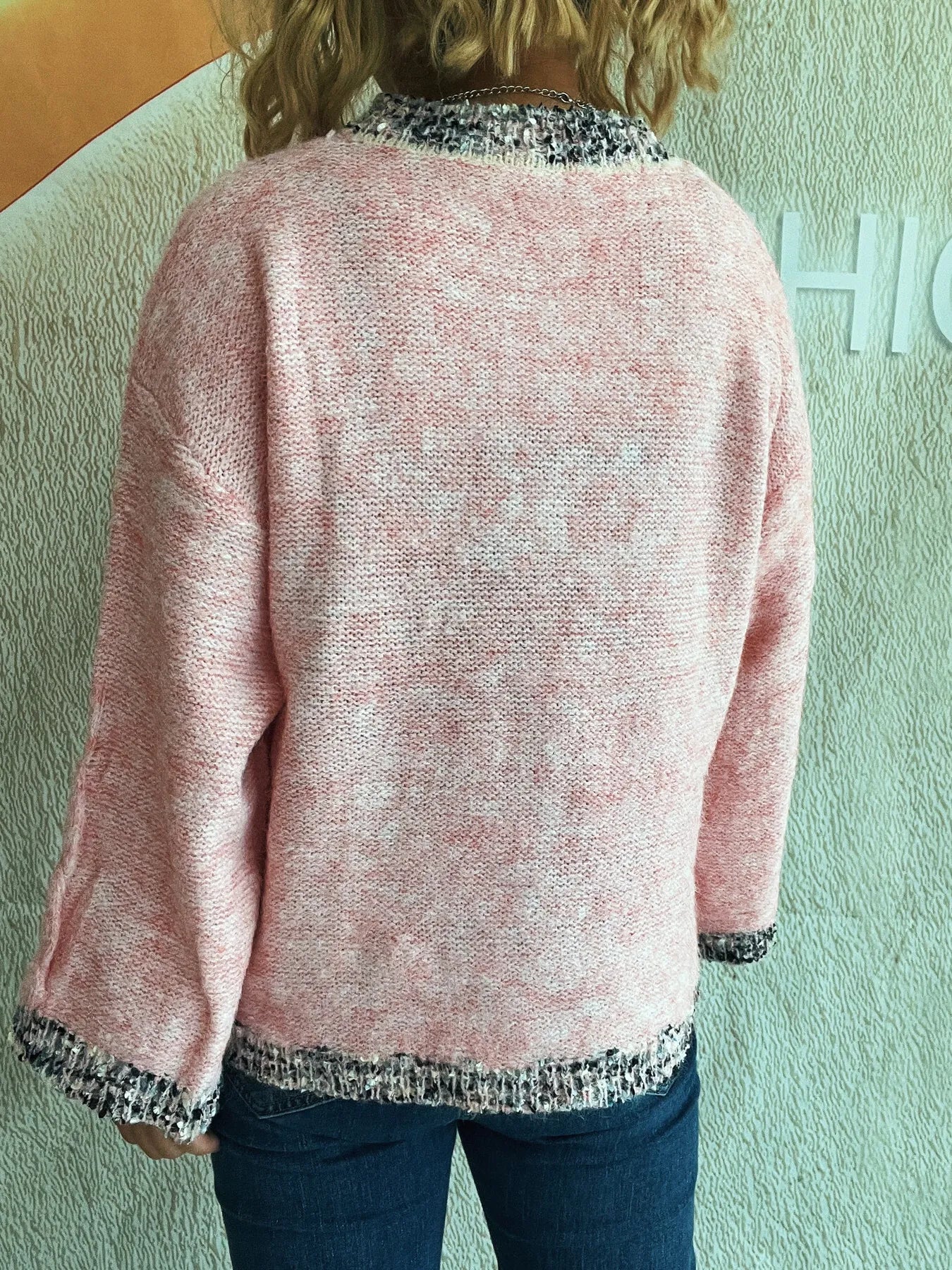 Pink back view round-neck sweater with contrast trim on sleeves and bottom hem.