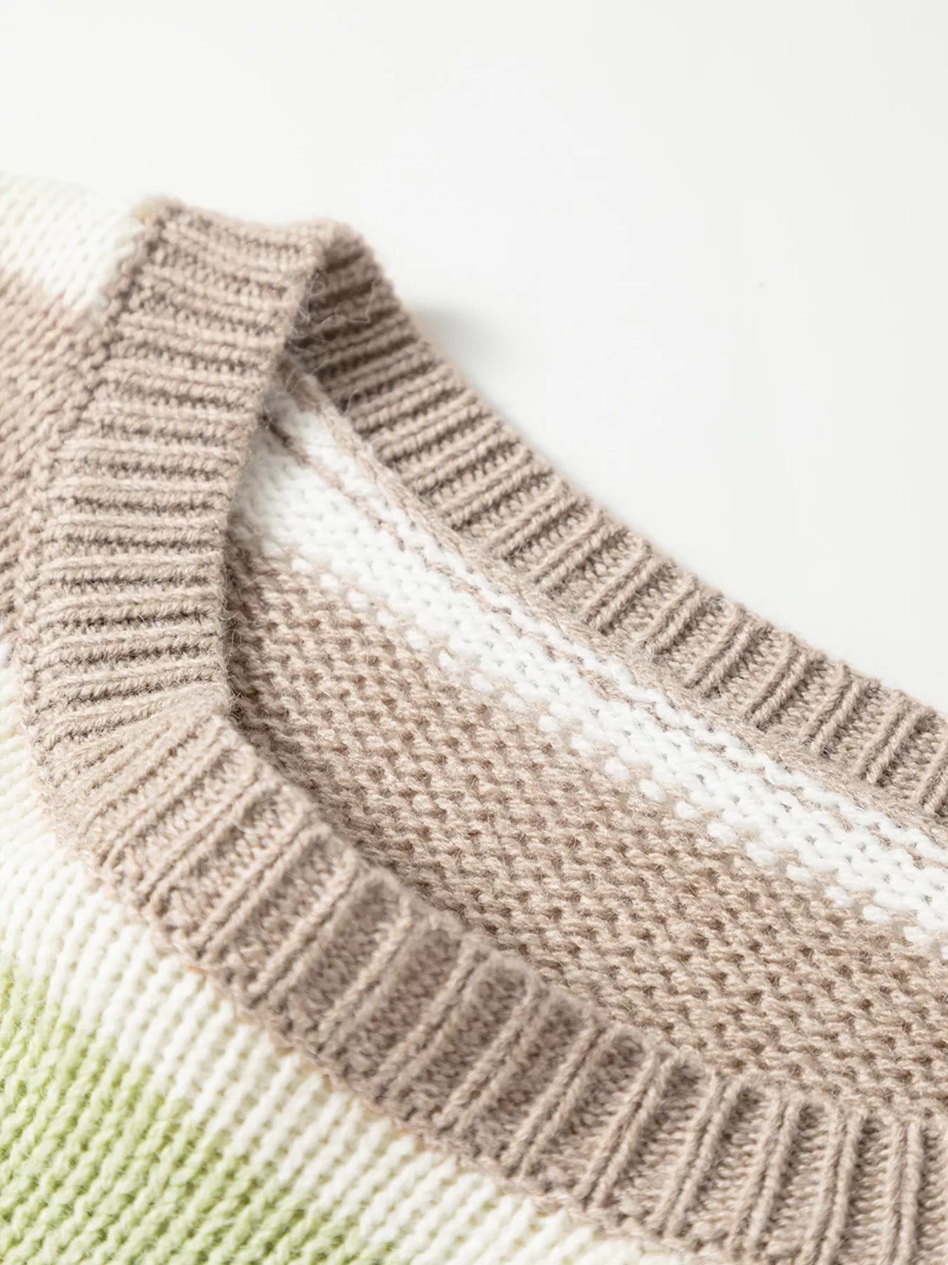 Striped sweater detail showing ribbed crew neckline and knit texture