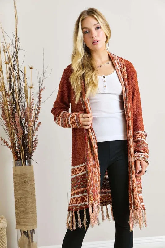 Rust aztec border cardigan with fringe edges and long sleeves, open front
