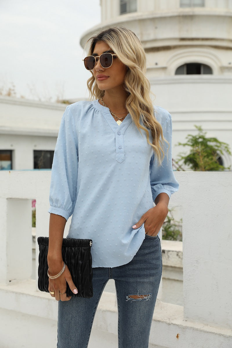 Light blue Swiss-dot blouse with notched V-neck and three-quarter puff sleeves, button front