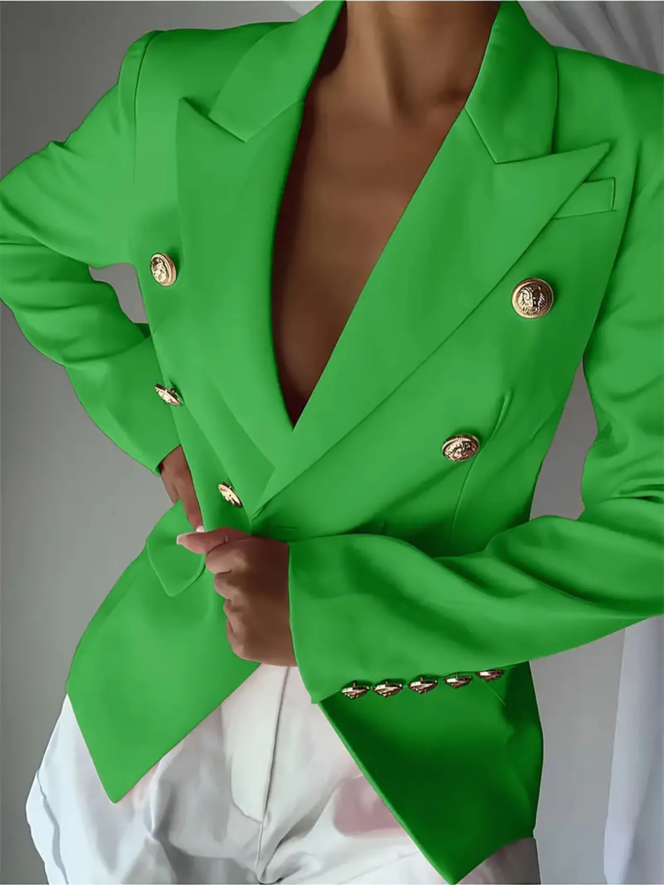 Green double-button lapel blazer with gold-tone round decorative buttons; fitted silhouette