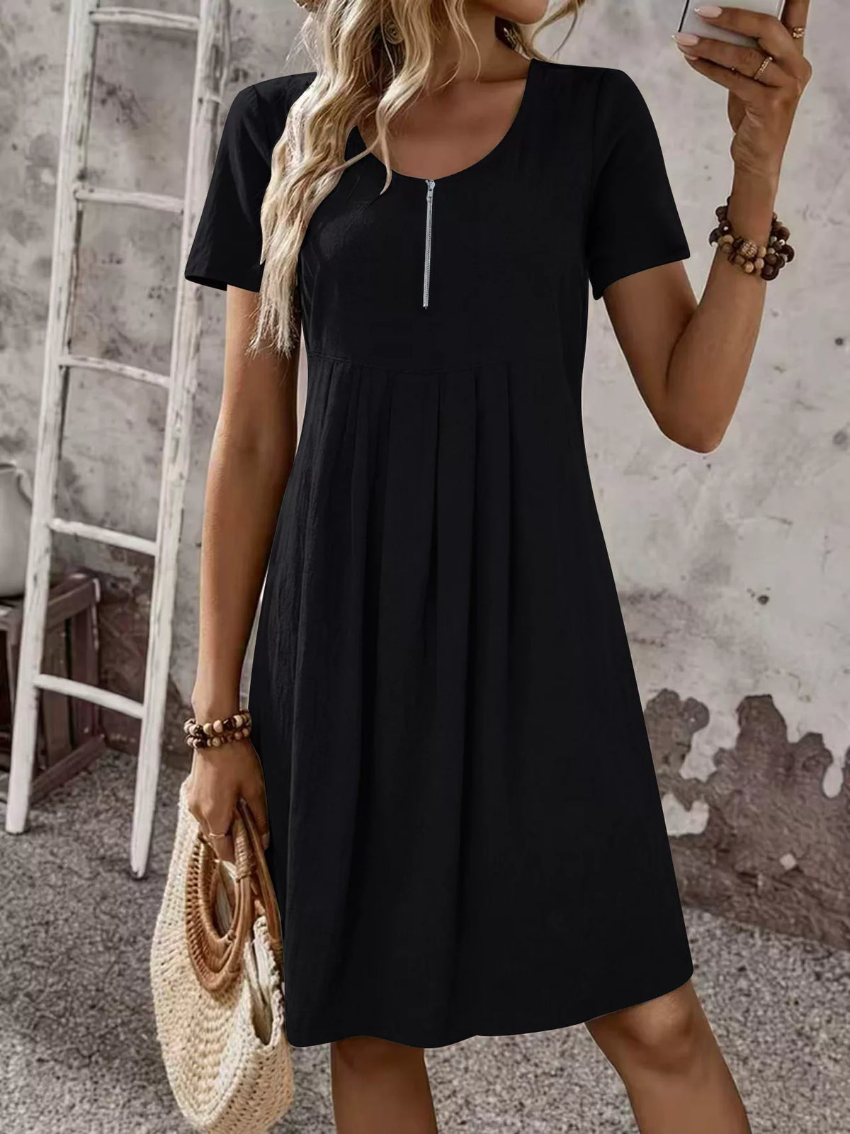 Black short-sleeve pleated dress with front zipper and scoop neckline