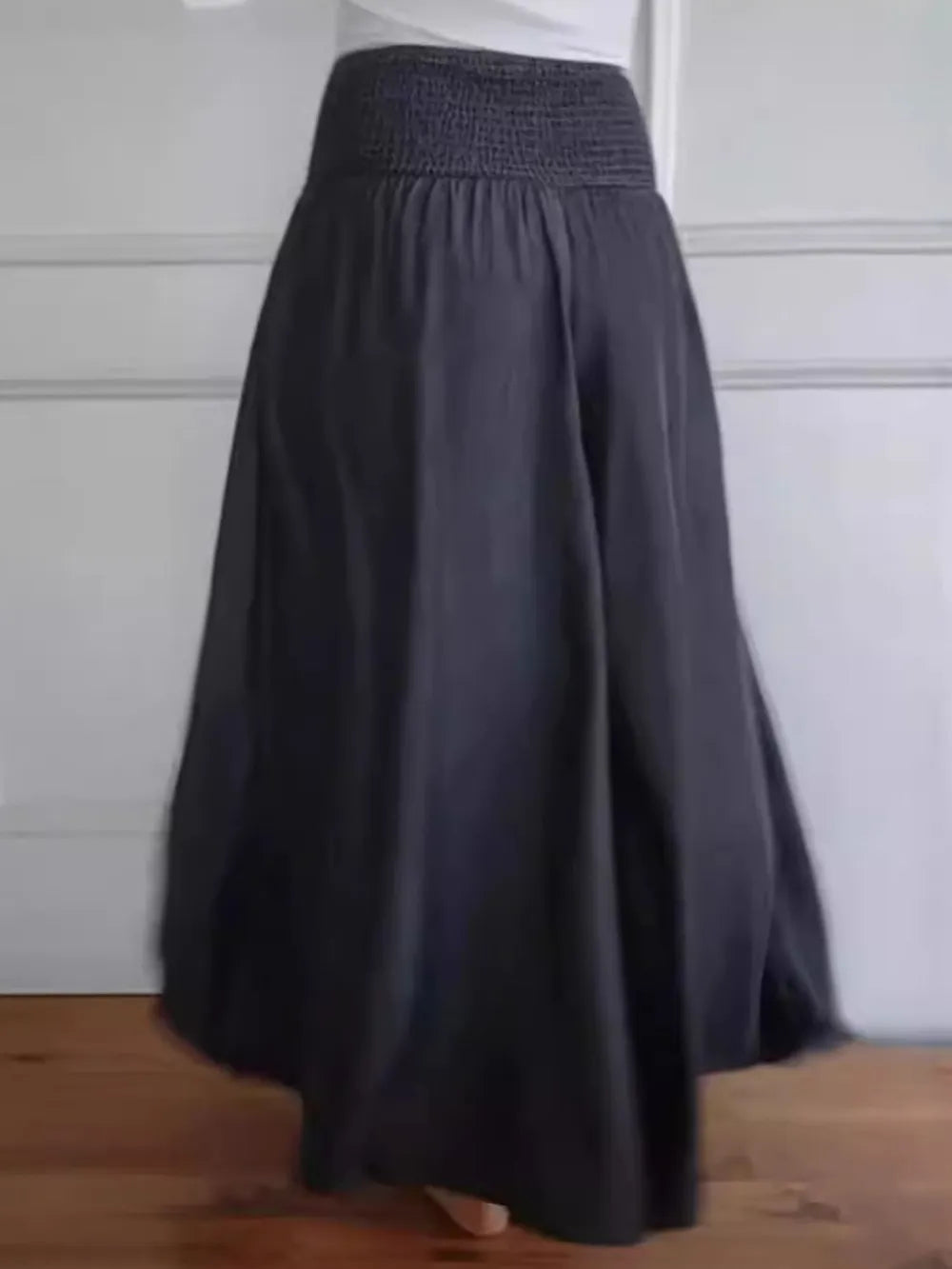 Black wide-leg pants with smocked elastic waistband and full gathered skirt