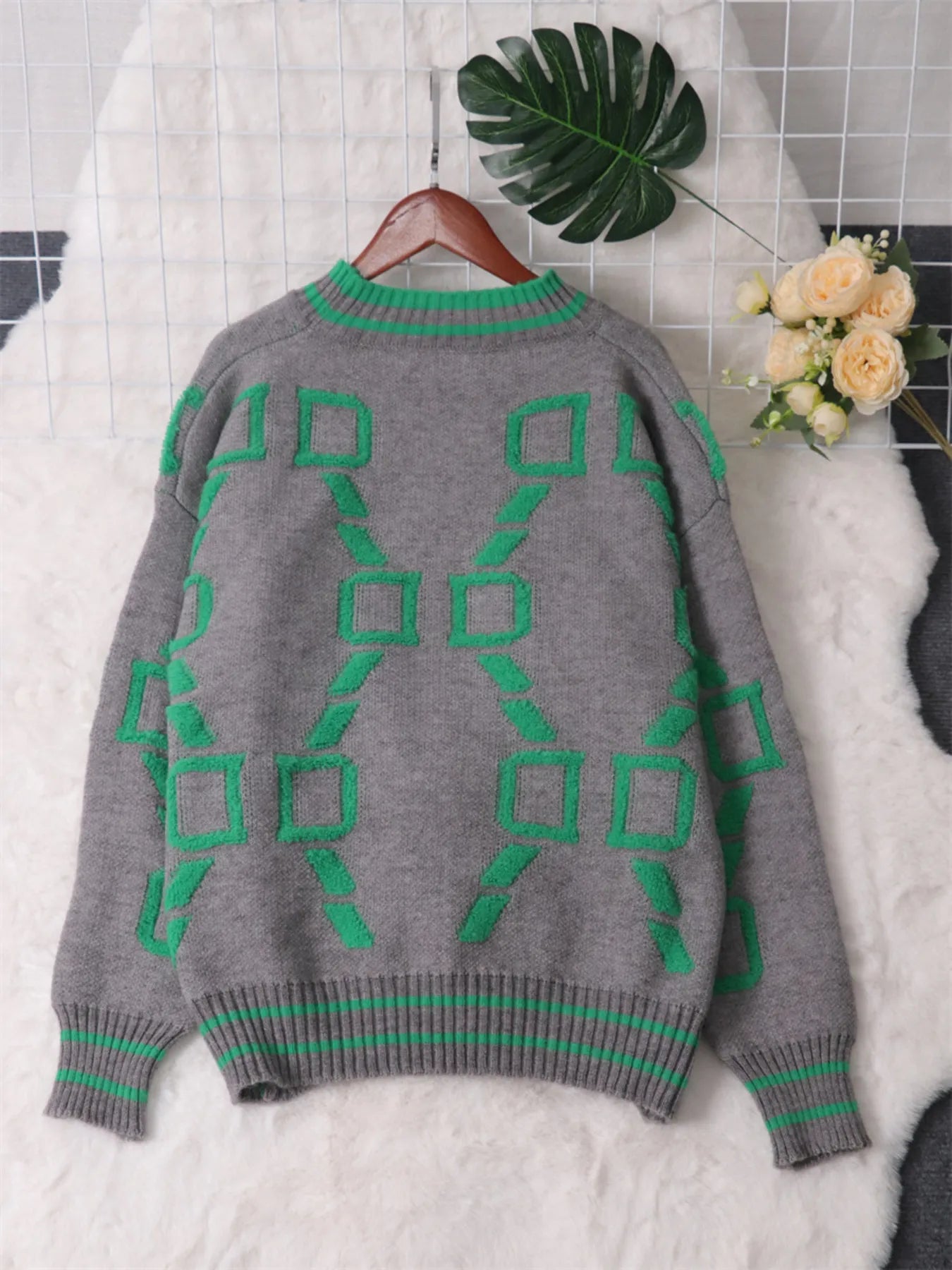 Grey sweater with green geometric pattern on back, ribbed neck and hem