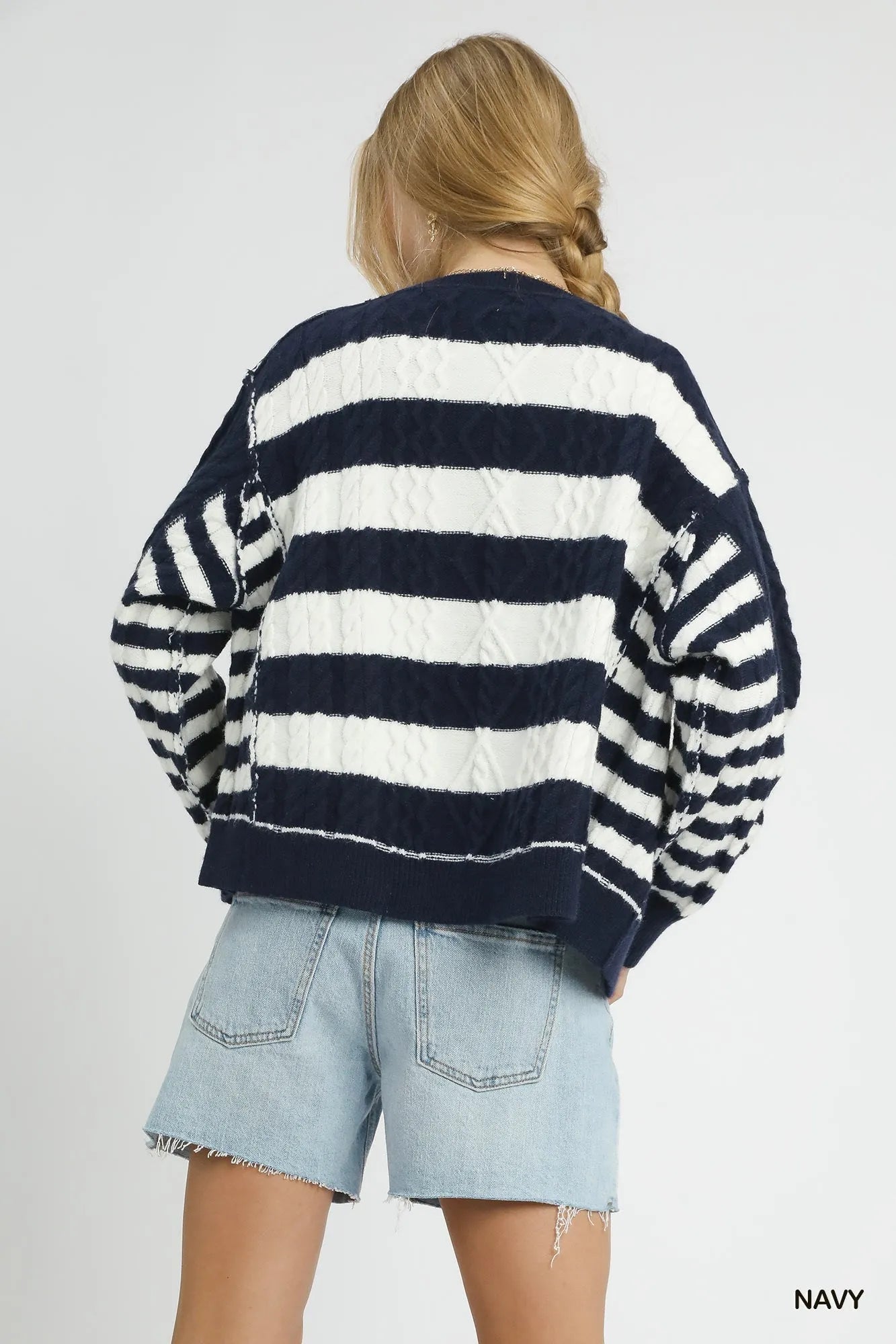 Back view navy and white striped cable-knit cardigan with button placket