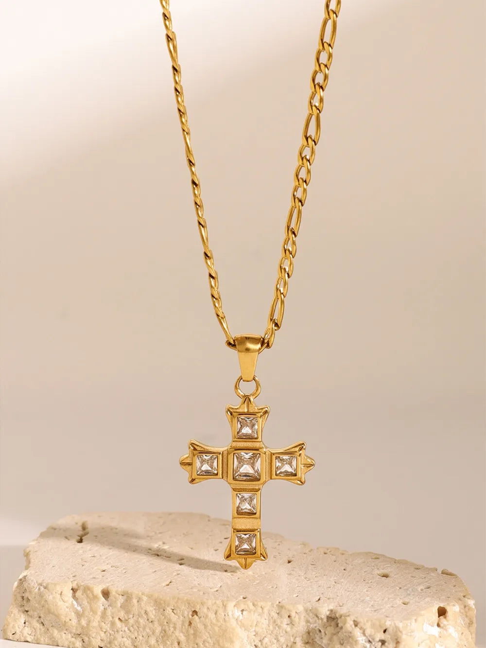 Gold-tone cross pendant necklace with clear square stones and a centered charm cross