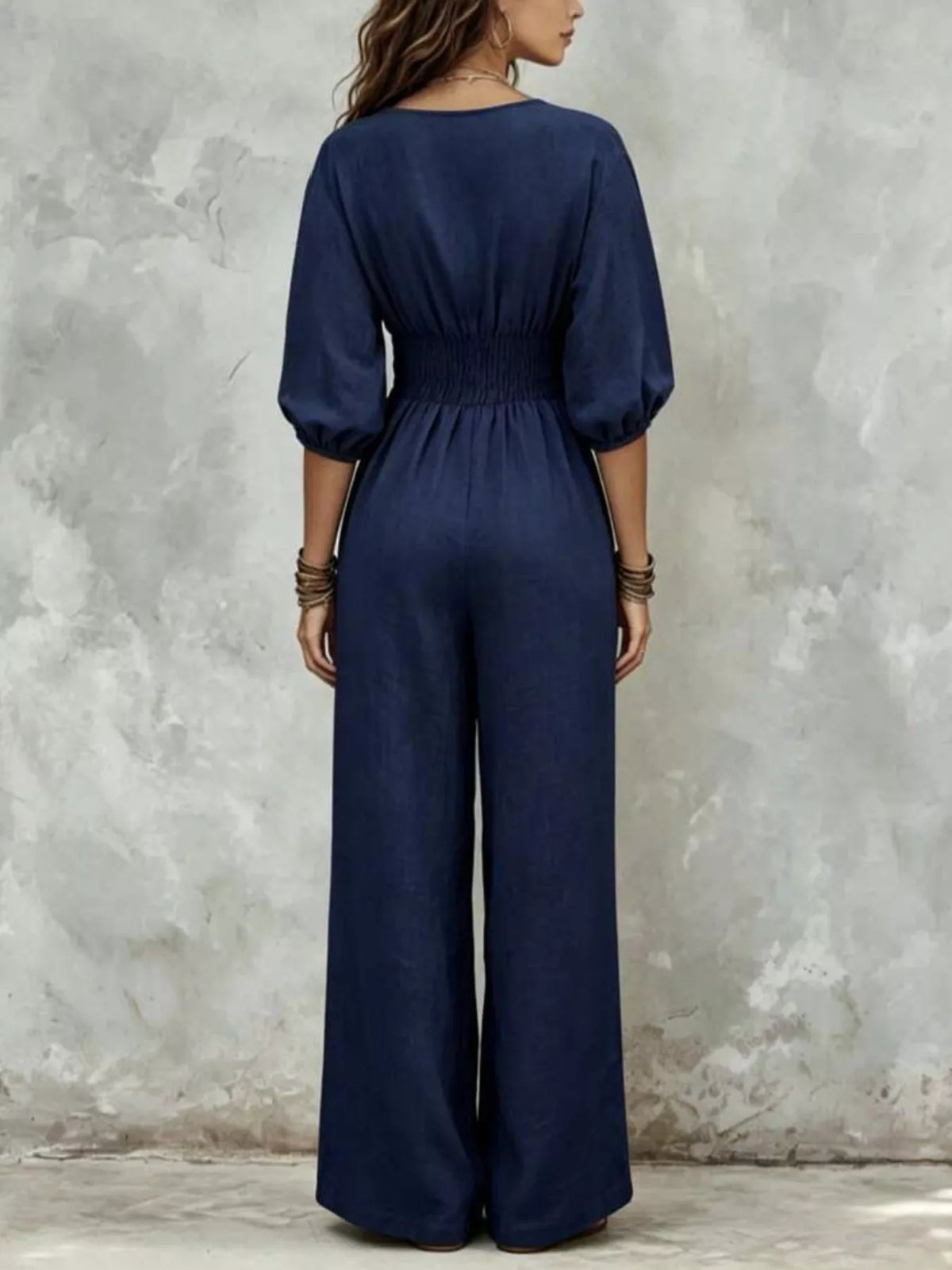 Navy v-neck smocked-waist wide-leg jumpsuit, back view