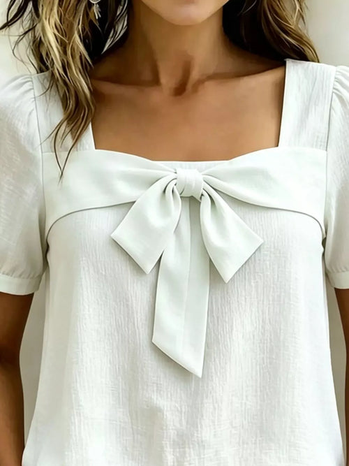 White square-neck blouse with puff sleeves and center bow detail