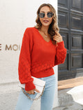 V-neck long-sleeve sweater in red-orange textured knit with ribbed cuffs and hem