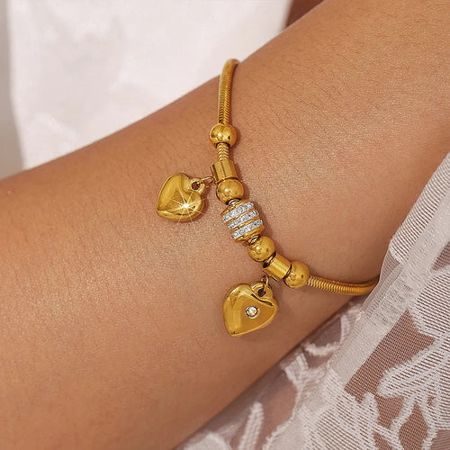 Gold-plated heart charm bracelet with dangling heart charms and rhinestone beads