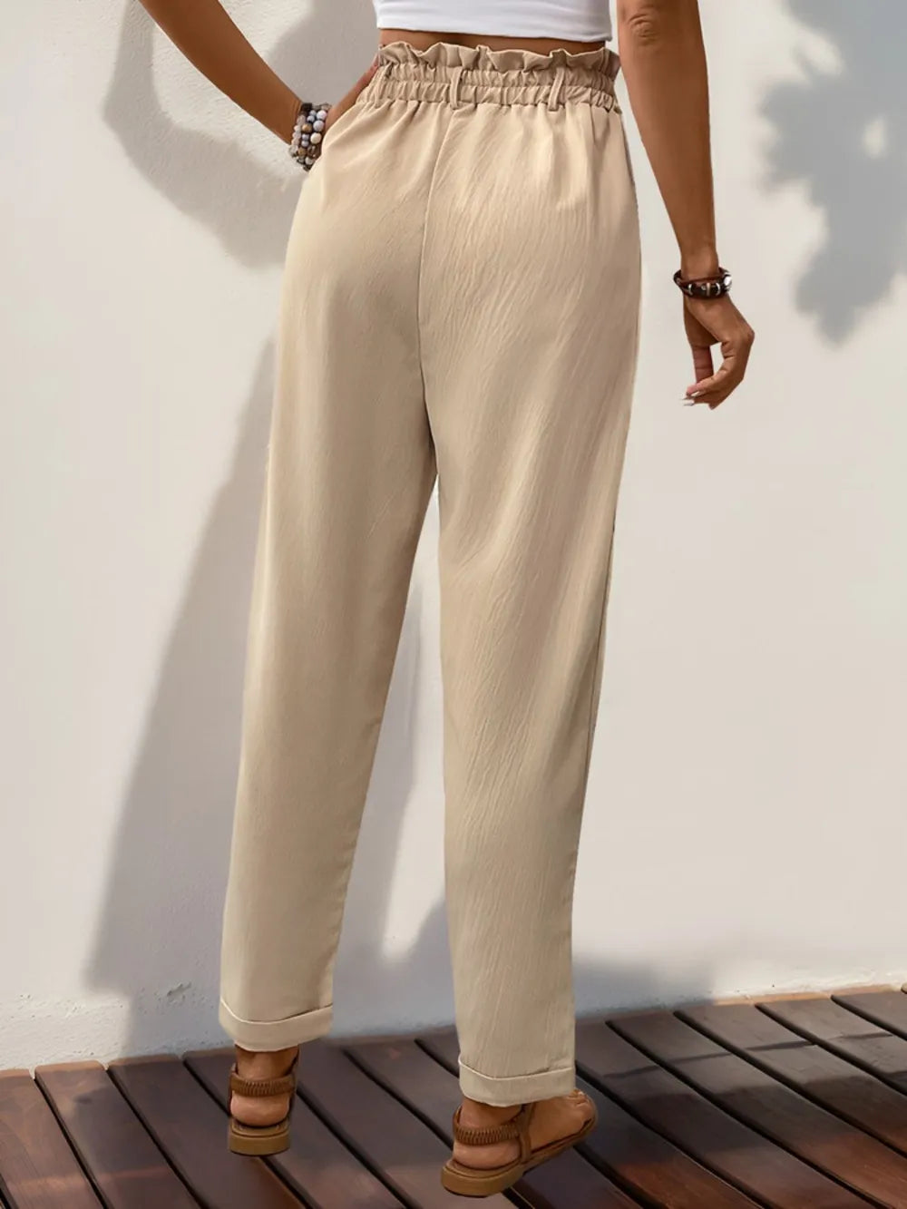 Tan high waist pants with elastic waistband, tapered legs, ankle length pockets