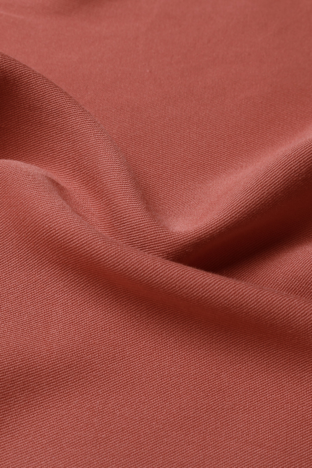 Rust red dress fabric close-up with fine woven texture