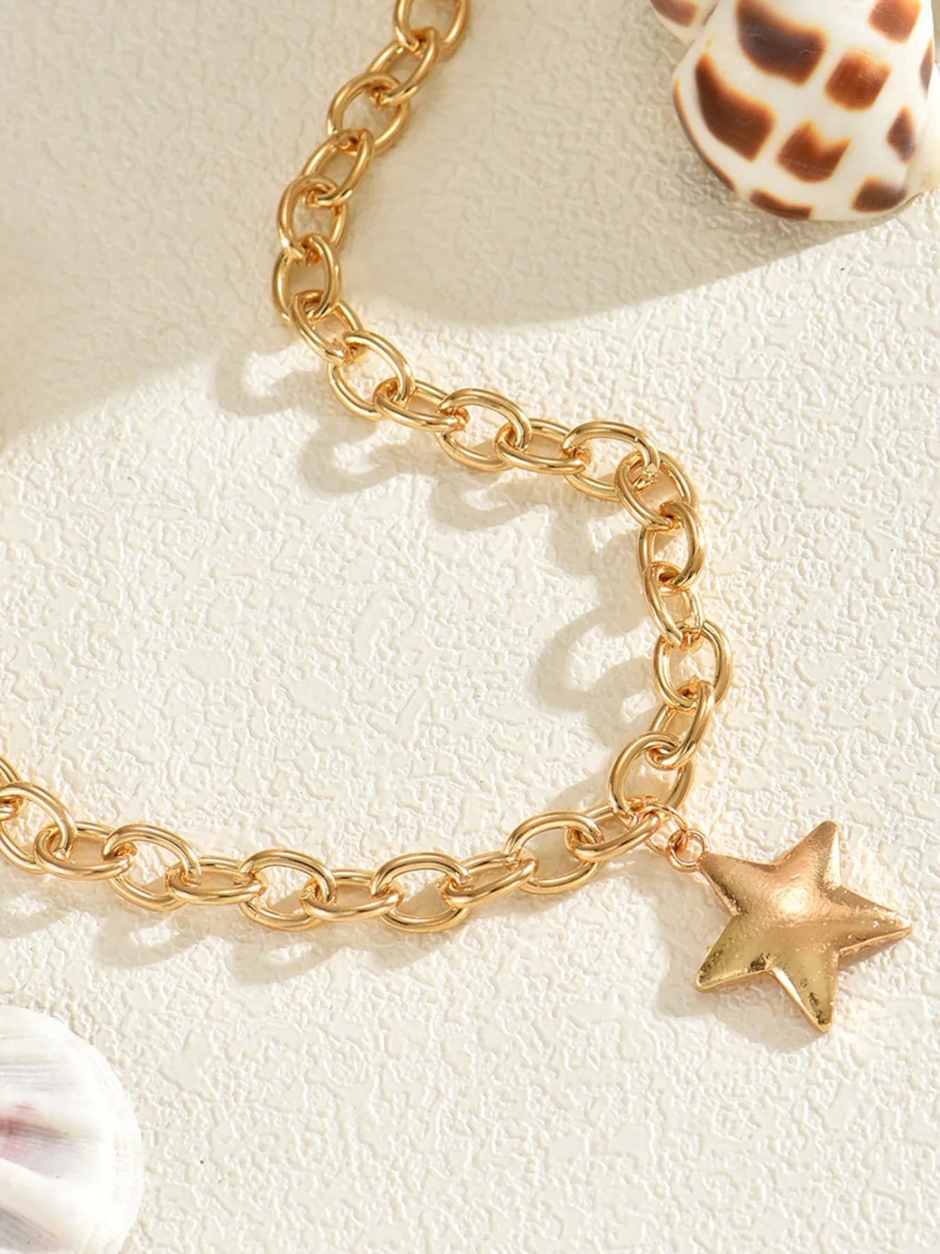 Gold plated chain necklace with star pendant detail, oval links and small star charm