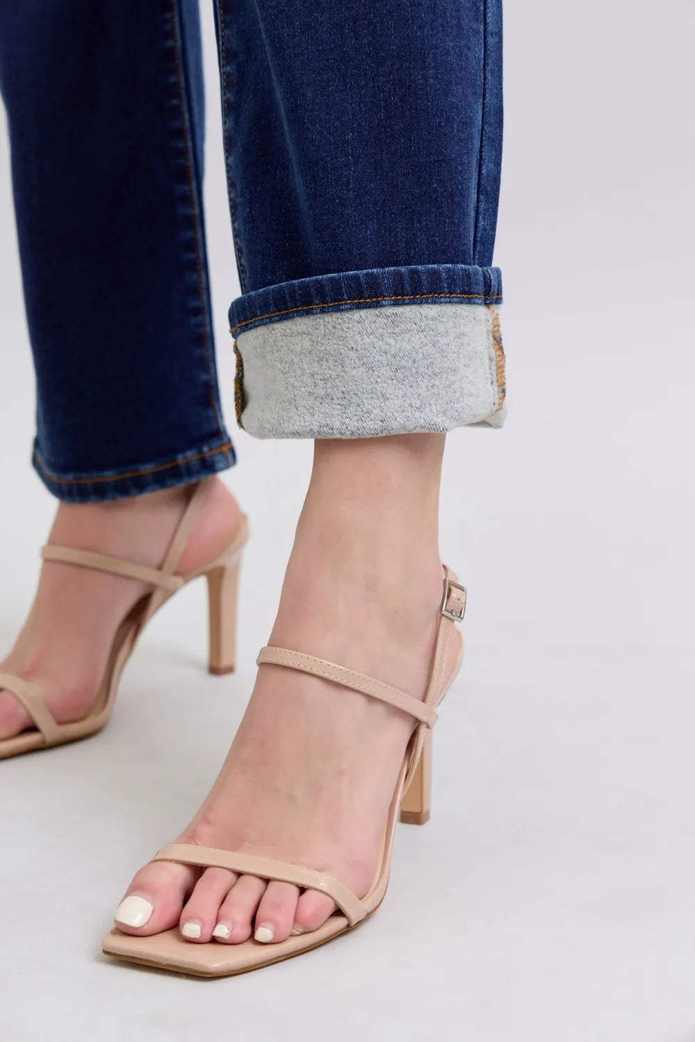 Dark blue straight-leg jeans with cuffed hem and light frayed denim edge