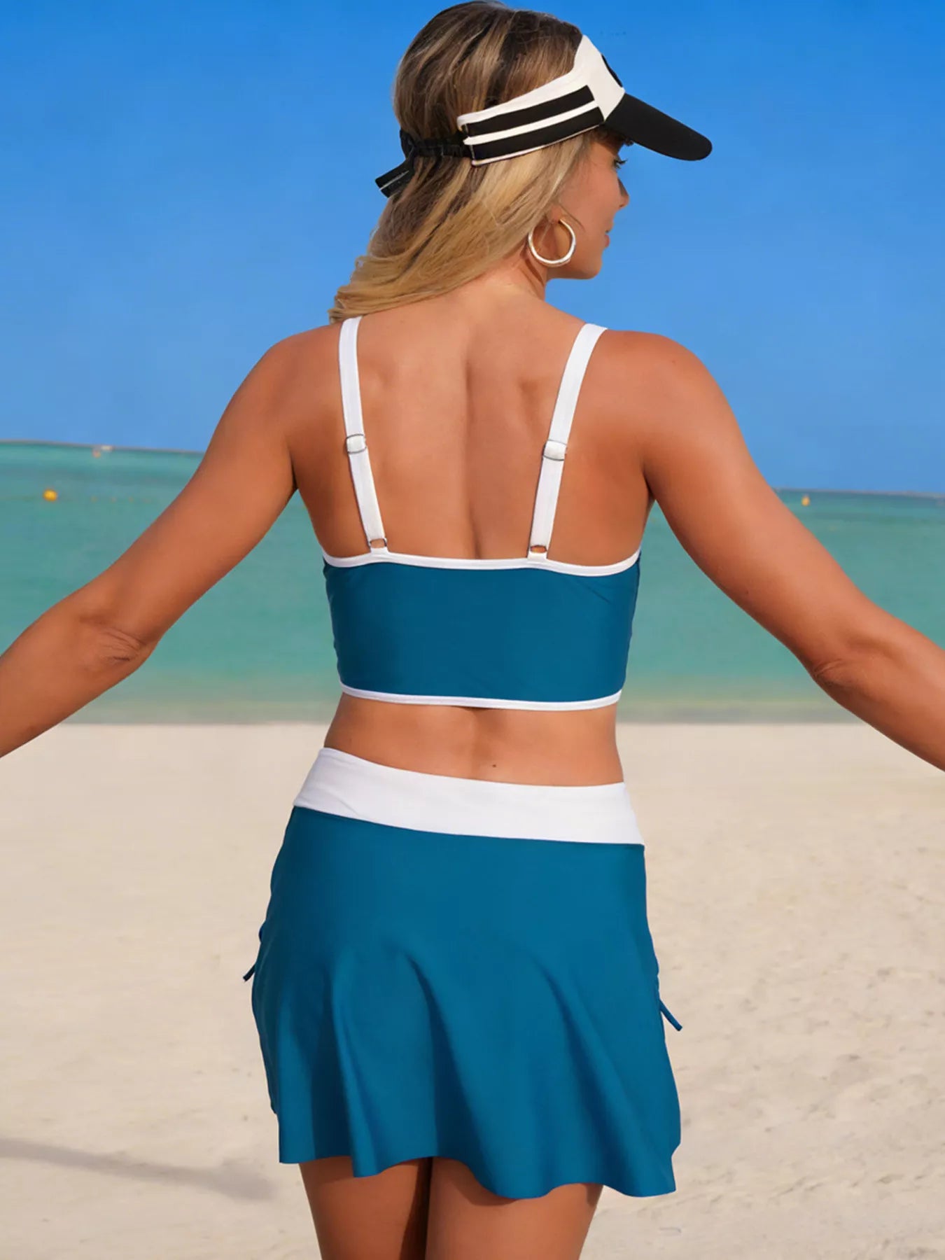 Two-piece contrast-trim swim set in teal with white straps and waistband; skirted bottom with slit