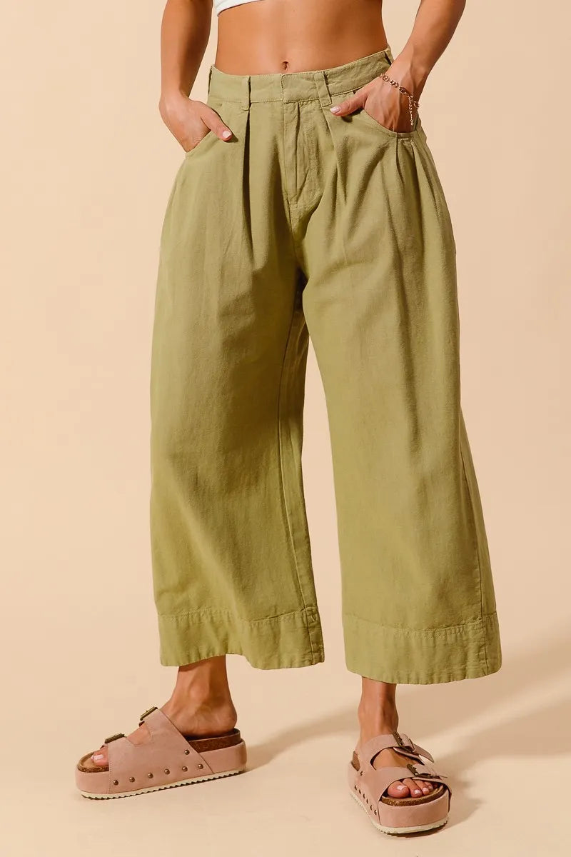 Sage green mid-rise wide-leg chino pants with side pockets and gathered waist