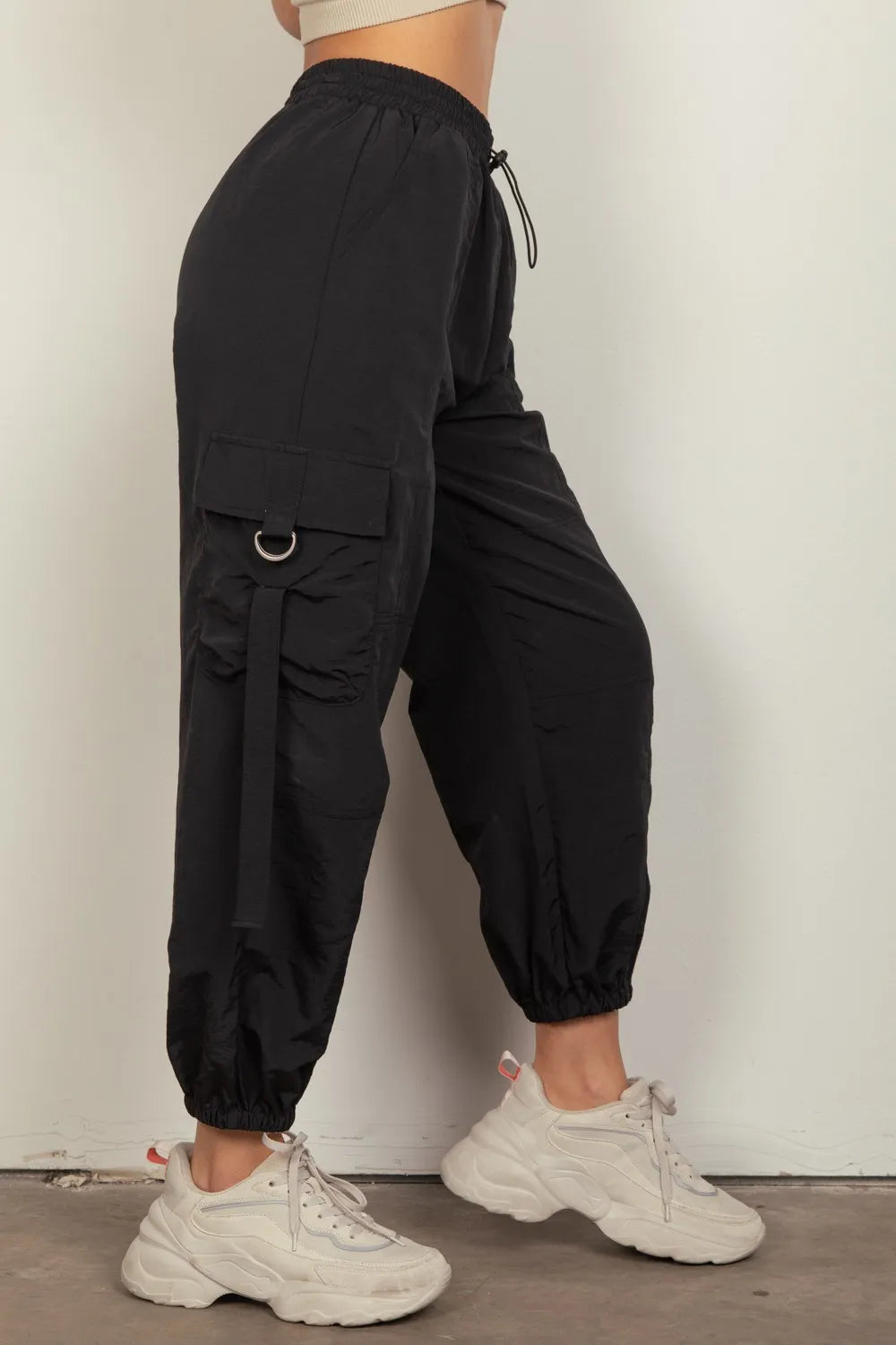 Black elastic-waist cargo pants with thigh cargo pocket detail and tapered cuffs