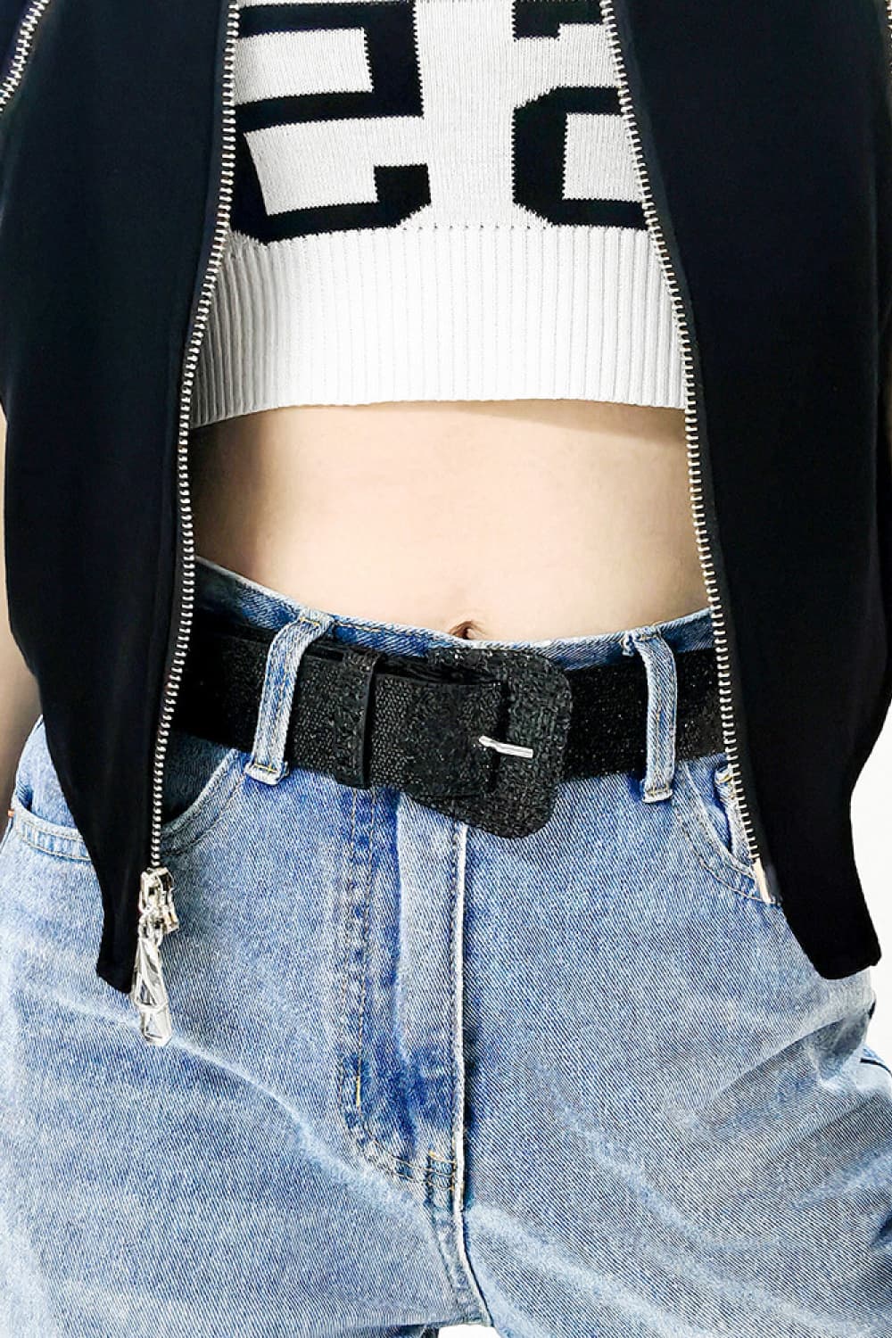 Black glitter vegan leather belt with rectangular buckle on light wash jeans