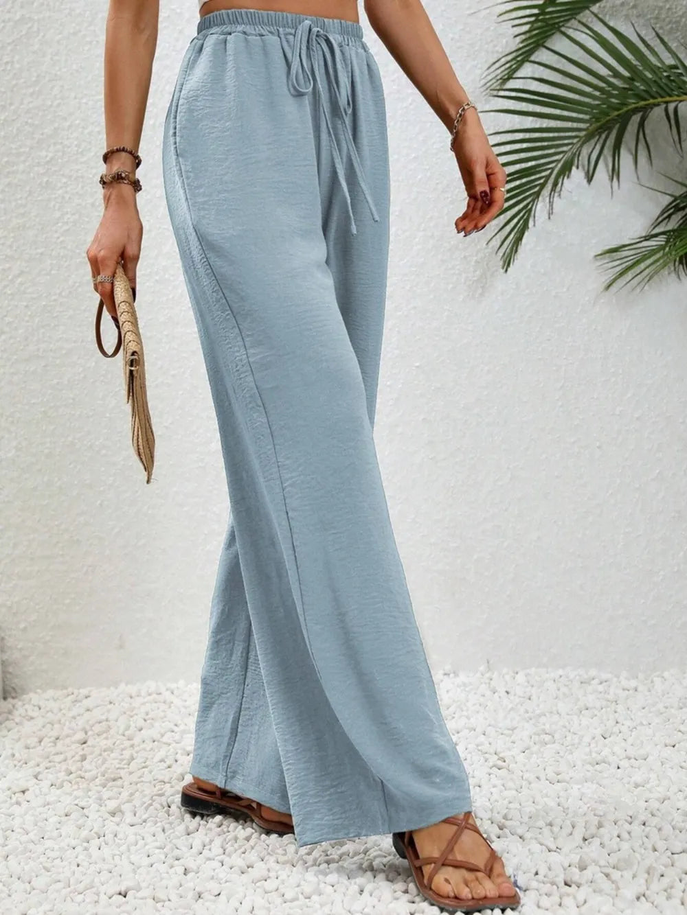 Light blue wide-leg drawstring pants with gathered waist and loose flared legs