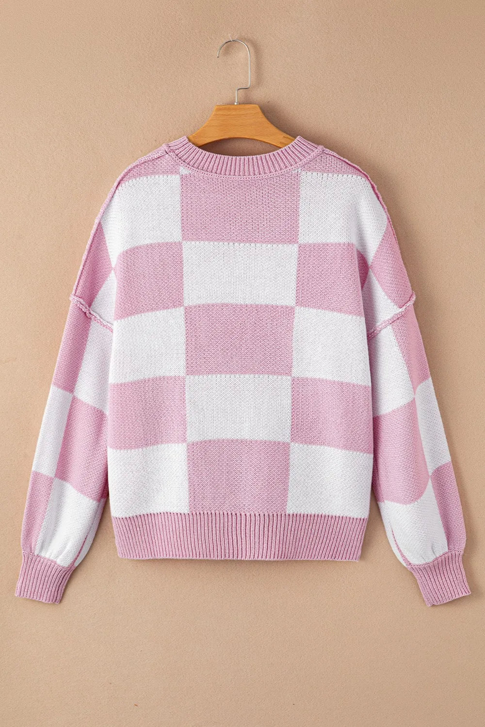 Pink and white checkered drooped-shoulder sweater, crew neck, long sleeves.