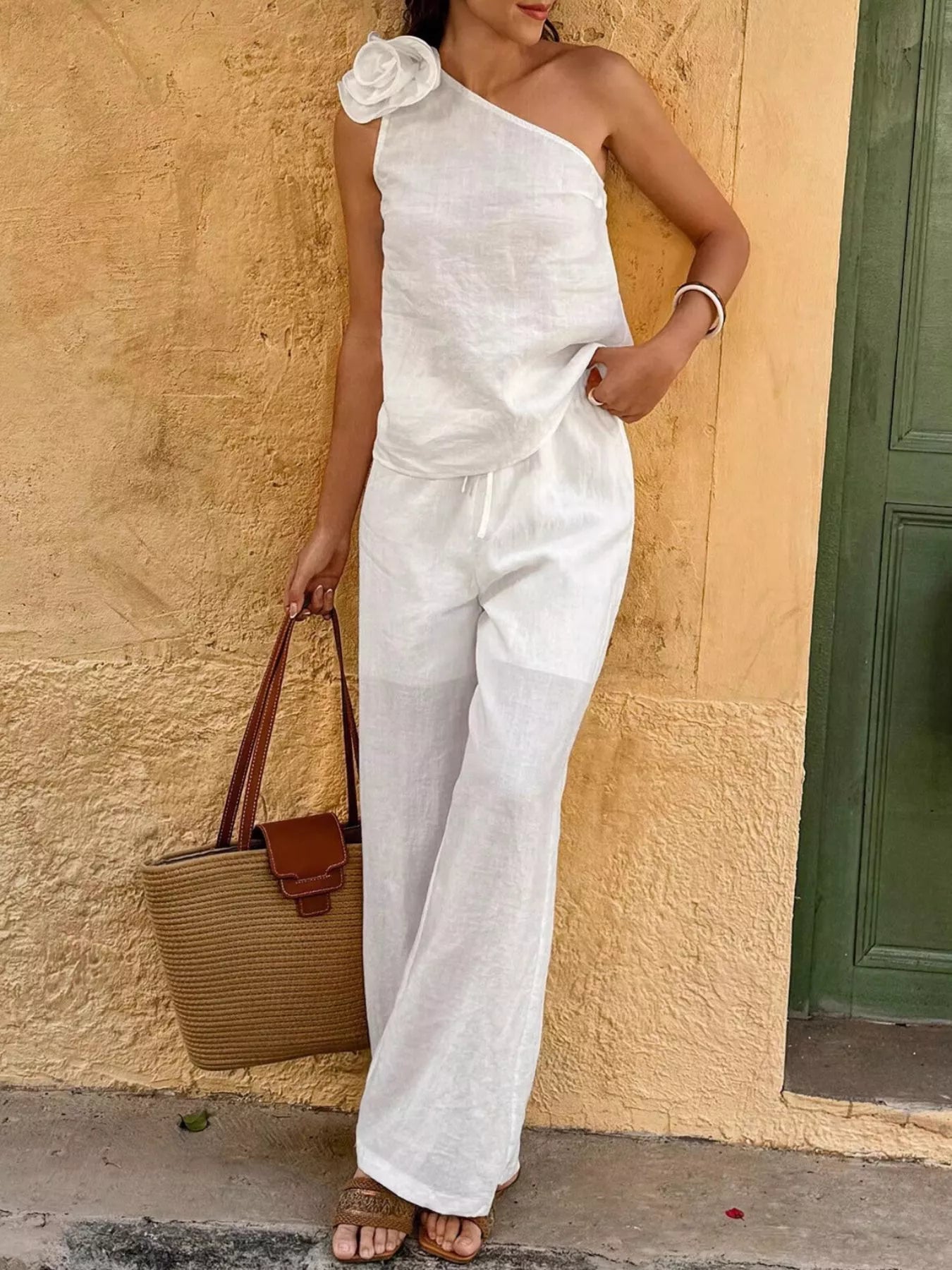 White one-shoulder floral embellished top paired with matching wide-leg pants